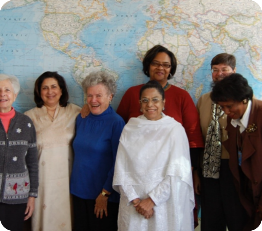 世界地図の前で笑顔の7人の女性たち